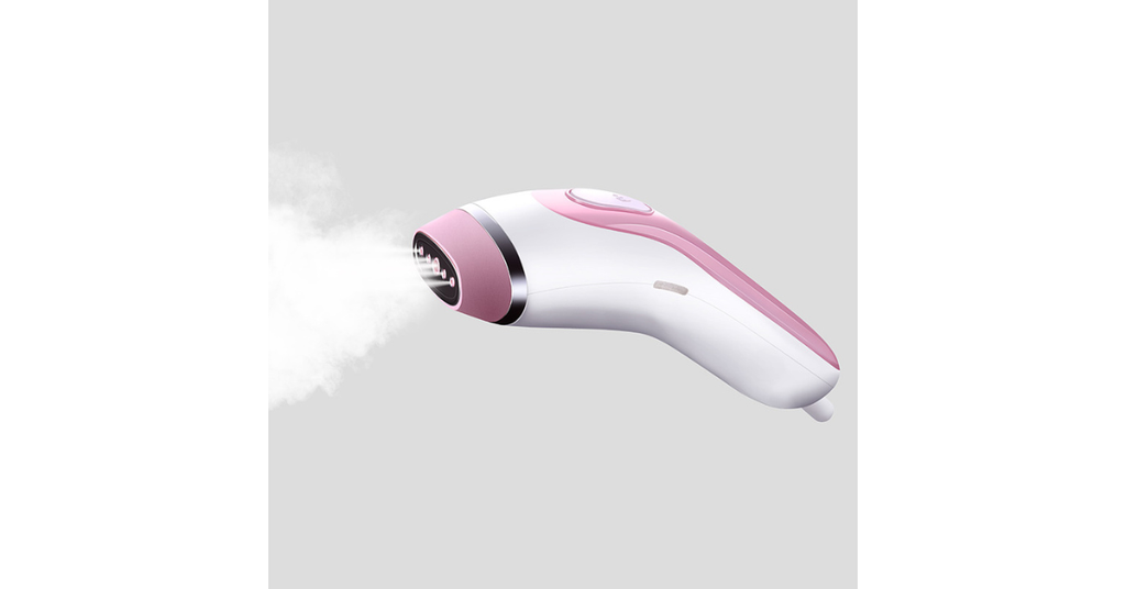 handheld clothes steamer in use